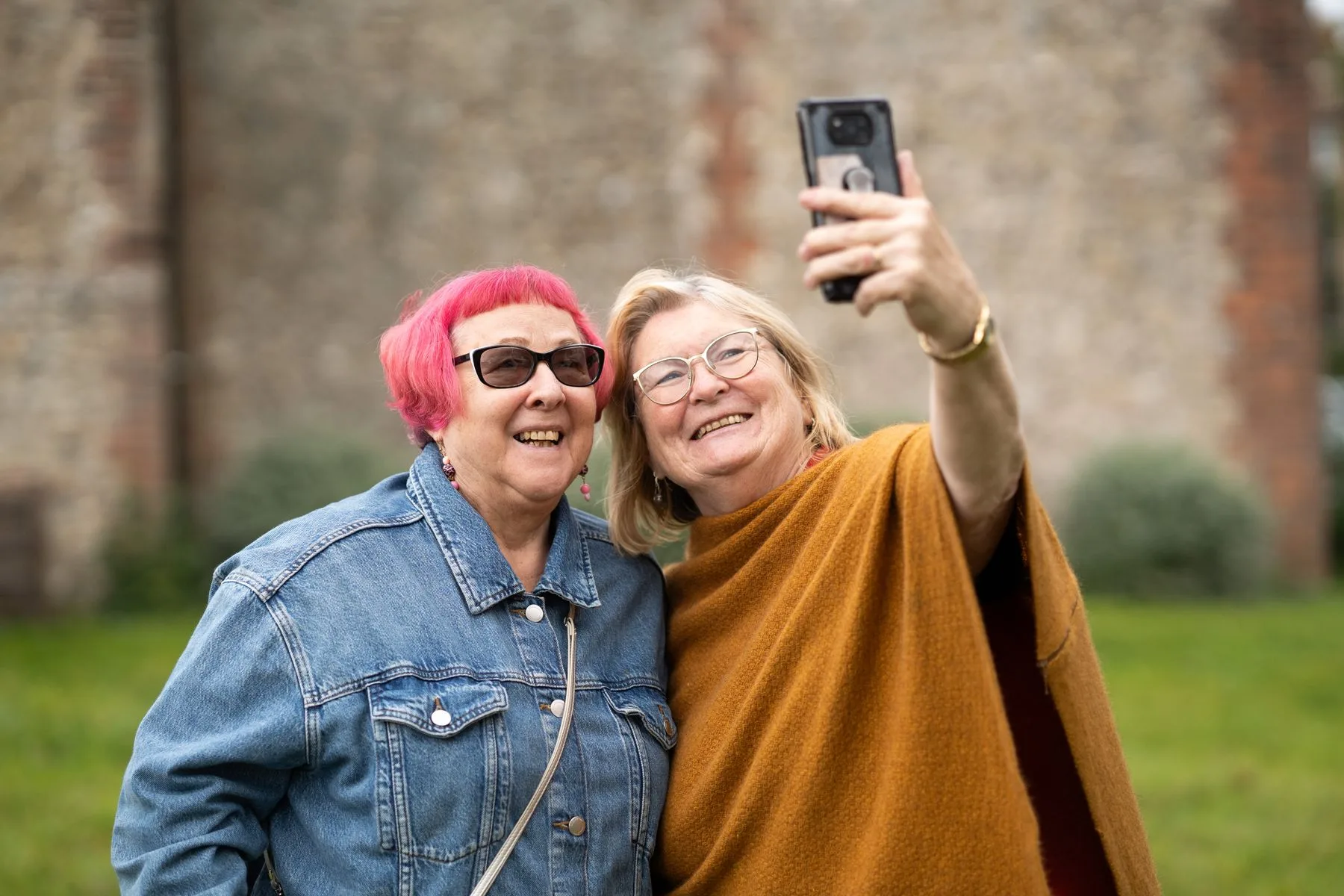 Zwei lachende Seniorinnen machen ein Selfie